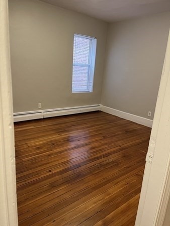 73 Charles Street, Unit 1 Boston, MA 02122 - Photo 2 of 7 a view of an empty room with wooden floor and a window
