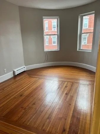 a view of a room with wooden floor and window