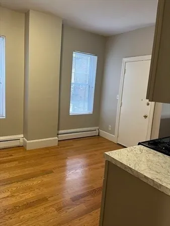 a view of room with window and wooden floor
