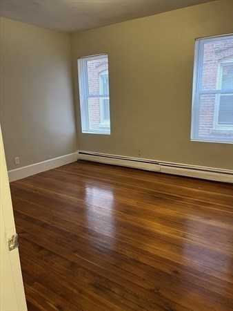 73 Charles Street, Unit 1 Boston, MA 02122 - Photo 7 of 7 a view of an empty room with wooden floor and a window
