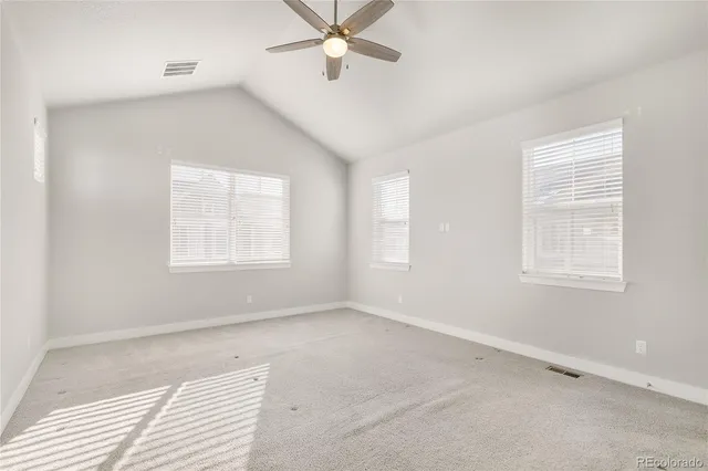 an empty room with a ceiling fan and a window