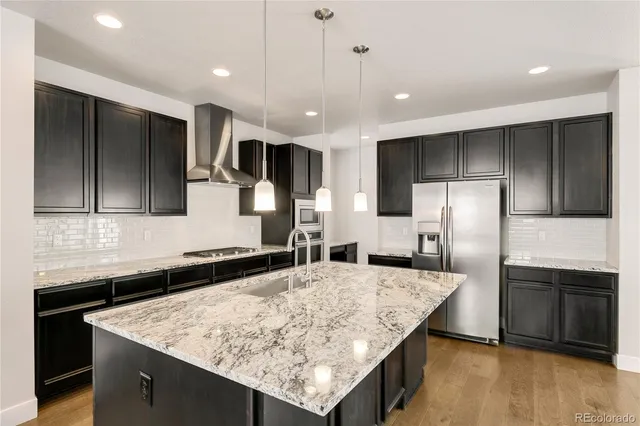a kitchen with stainless steel appliances a refrigerator stove and kitchen island