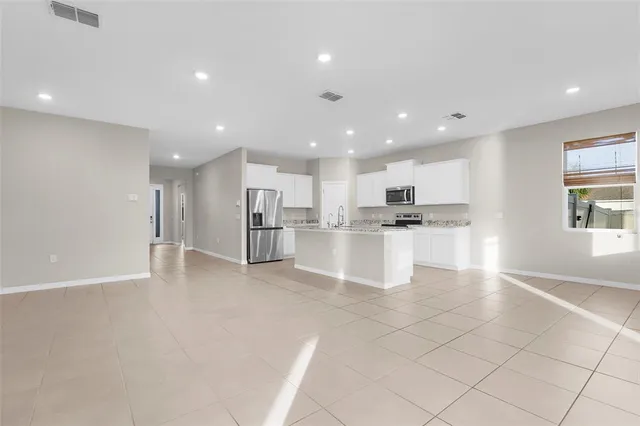 a view of kitchen with kitchen island and stainless steel appliances