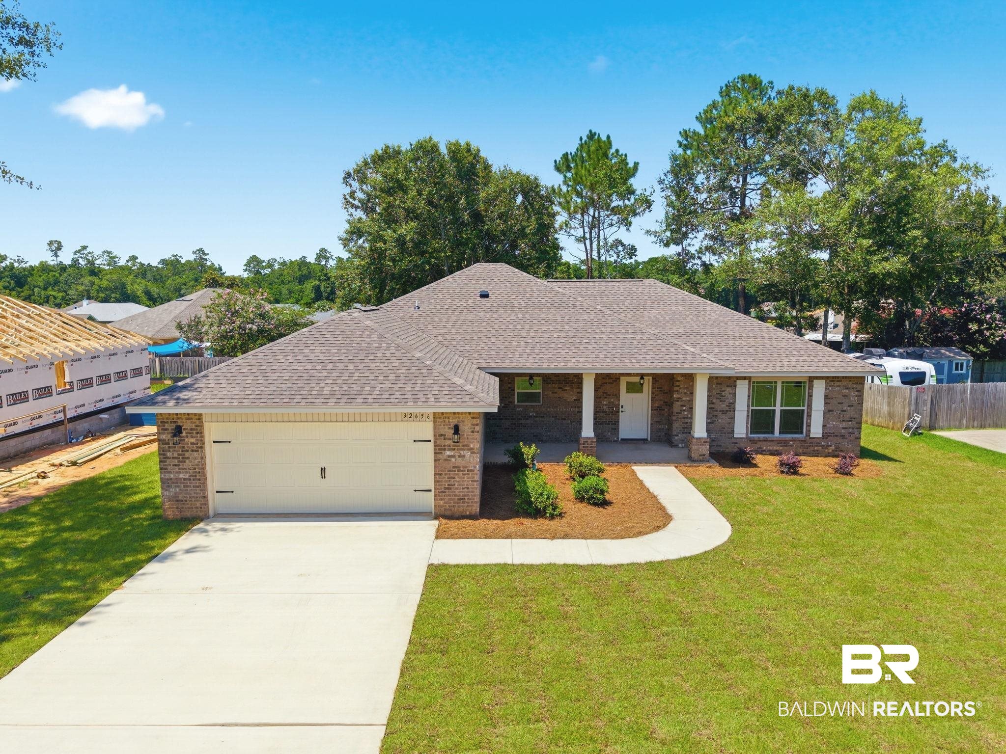 32656 Arbor Ridge Circle Lillian, AL 36549 - Photo 39 of 56 Brick exterior featuring an attached two-car garage, concrete driveway, and covered front entry