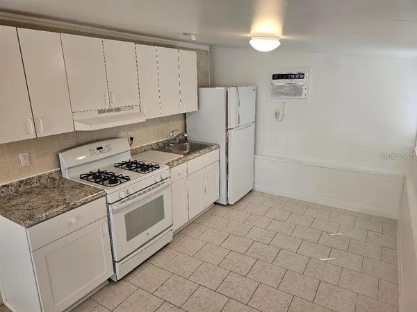a kitchen with white cabinets and white appliances