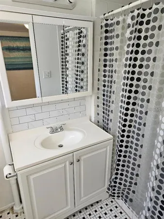 a bathroom with a sink a vanity and a shower