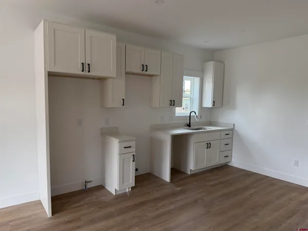 a kitchen with sink cabinets and wooden floor