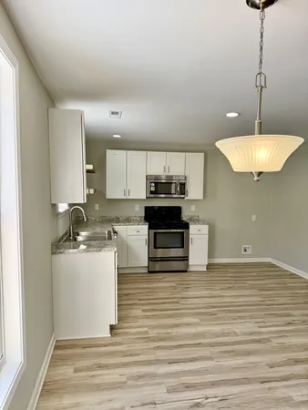 a kitchen with stainless steel appliances granite countertop a sink a stove and a refrigerator