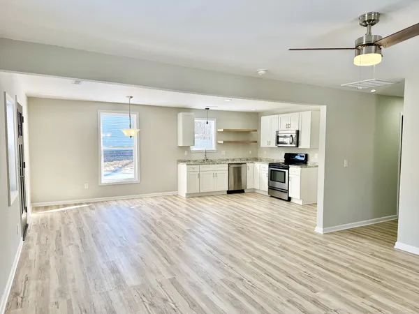 a view of a kitchen with a sink and dishwasher a refrigerator with wooden floor