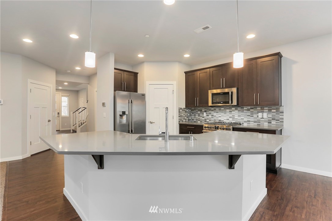 22720 41st Drive Southeast Bothell, WA 98021 - Photo 5 of 33 a large kitchen with stainless steel appliances a large counter top and a refrigerator