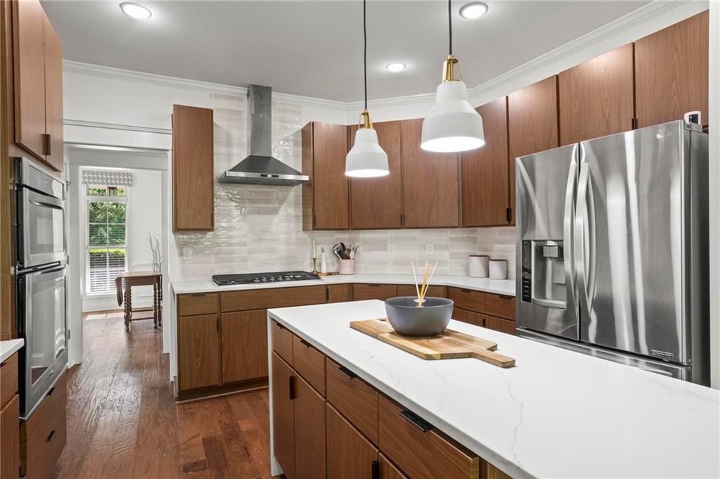183 Lullwater Lane Dallas, GA 30132 - Photo 13 of 40 a kitchen with stainless steel appliances a sink a stove a refrigerator and island with wooden floor