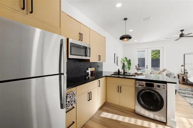 a kitchen with stainless steel appliances granite countertop a refrigerator a stove a sink and a microwave