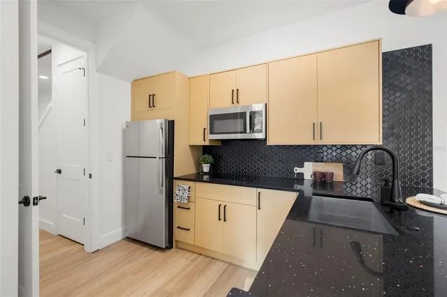 a kitchen with stainless steel appliances a refrigerator sink and cabinets