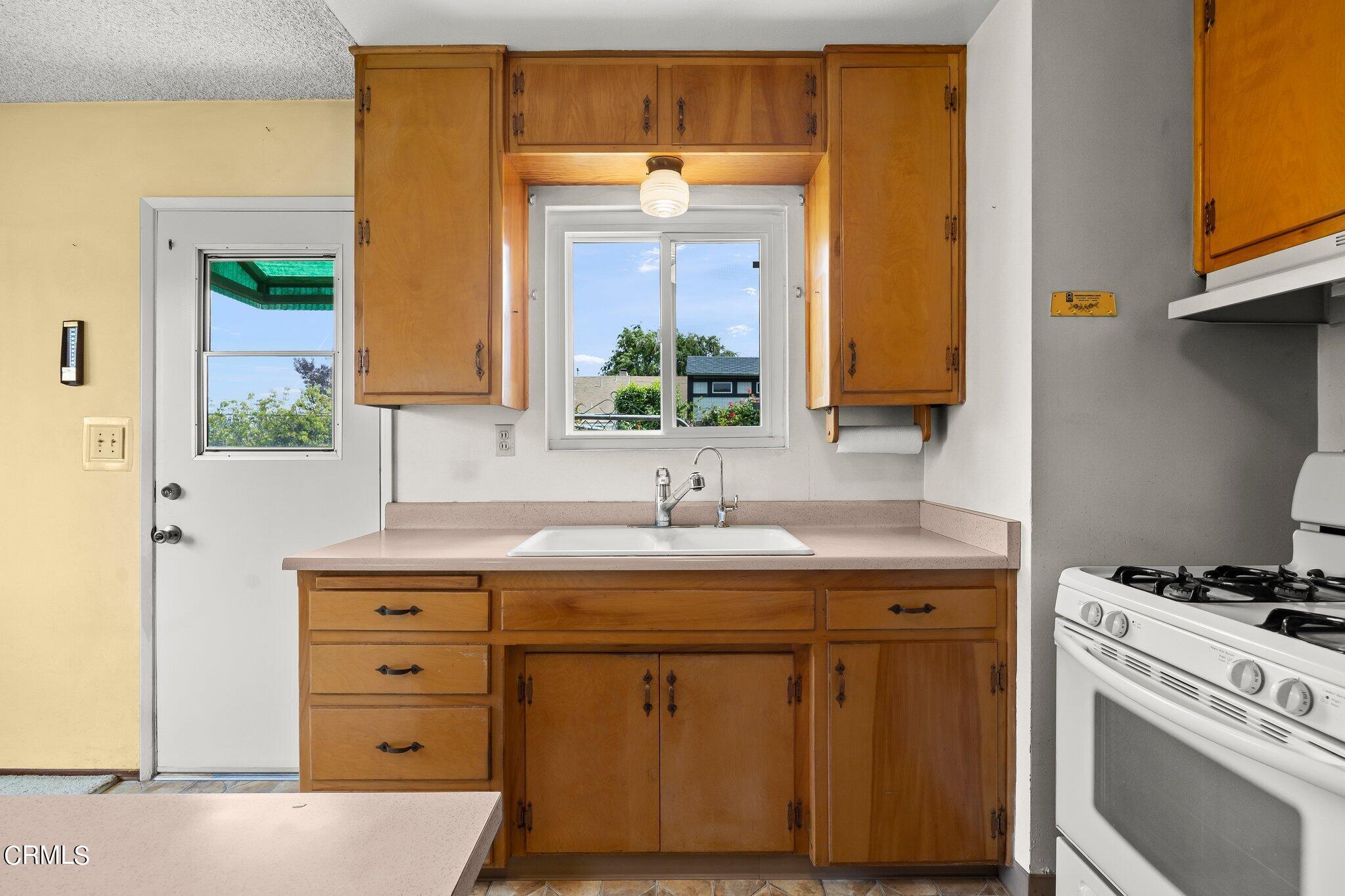 4989 Strickland Drive Oxnard, CA 93036 - Photo 12 of 26 a kitchen with a sink stove and cabinets