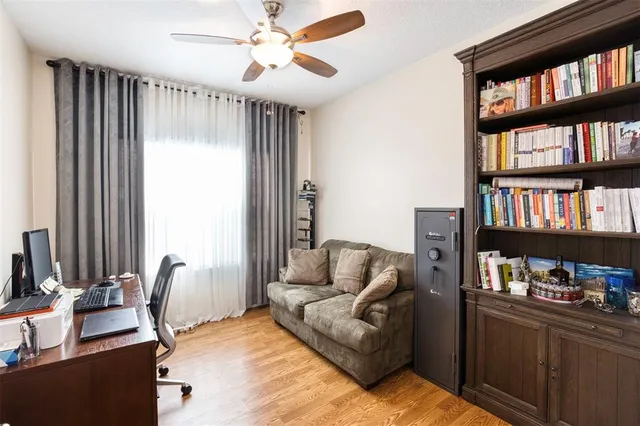 a living room with furniture a bookshelf and a window