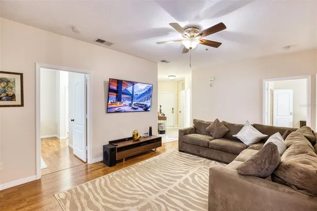 a living room with furniture a ceiling fan and a rug