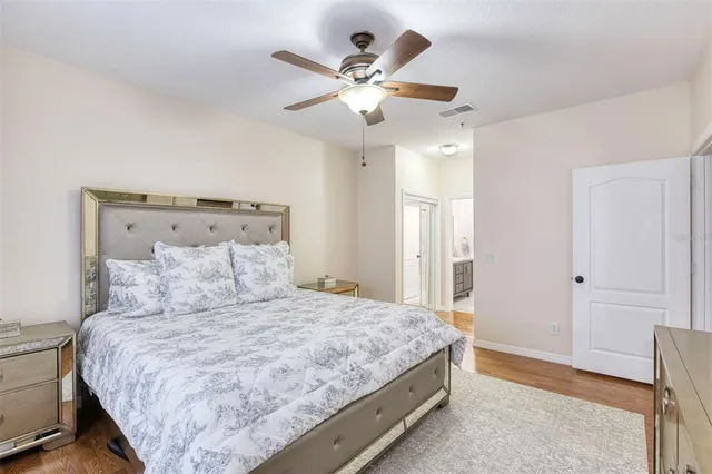a bedroom with a large bed and a ceiling fan