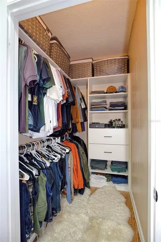 a view of walk in closet with clothes and shoes