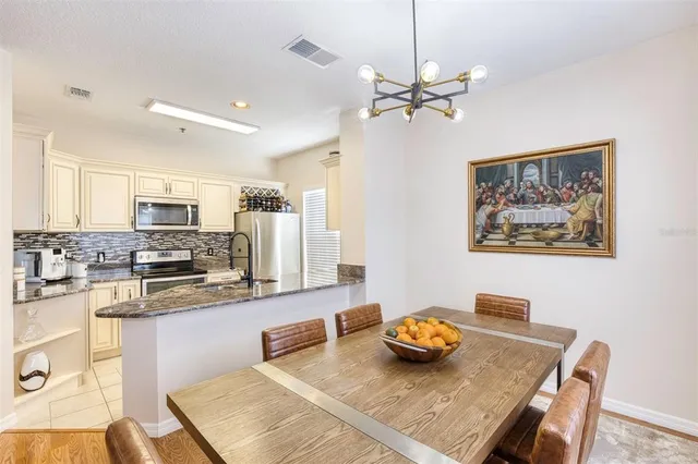 a kitchen with stainless steel appliances granite countertop a sink counter space and dining table