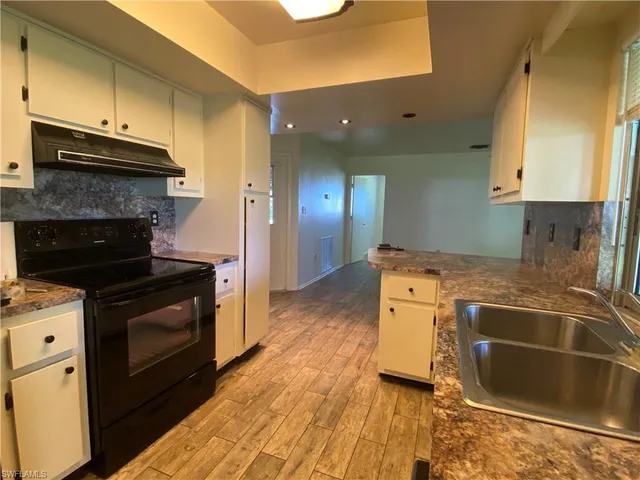 a kitchen with a sink stove and cabinets