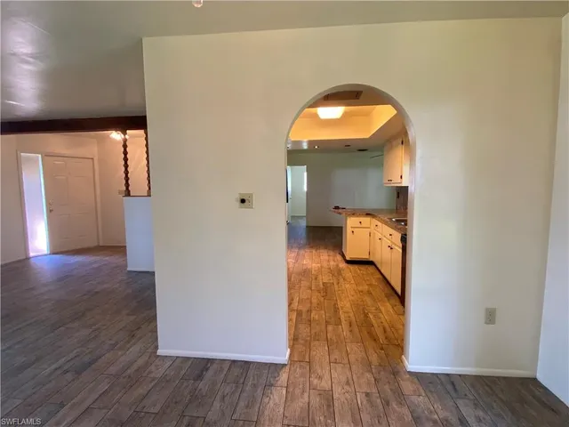 a view of a livingroom with furniture wooden floor chandelier and windows