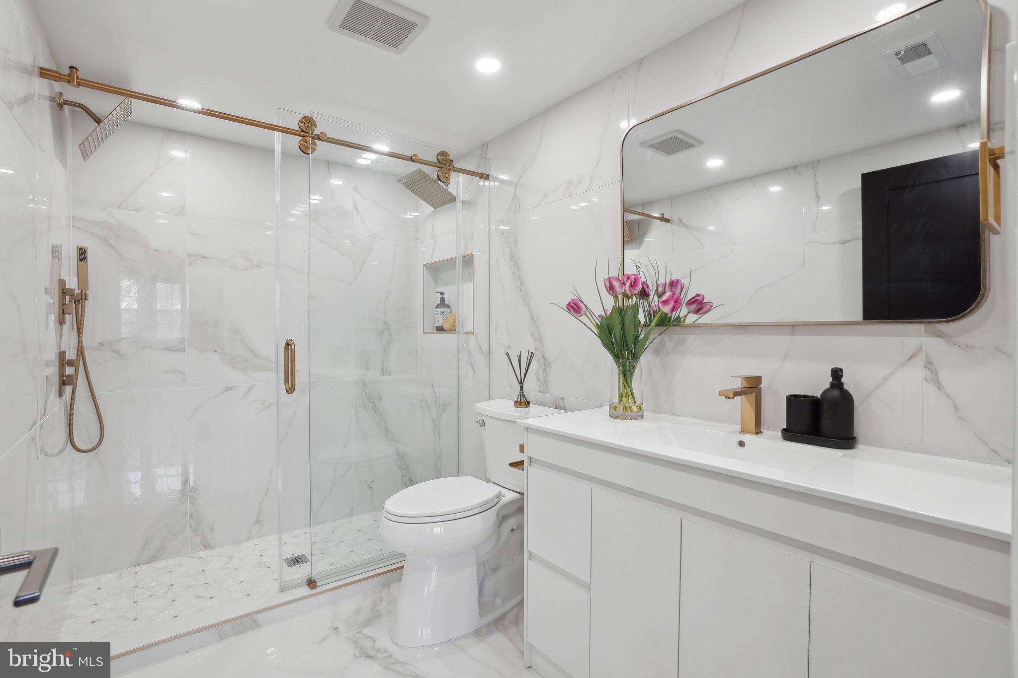 4423 Volta Place Northwest Washington, DC 20007 - Photo 15 of 36 a bathroom with a shower sink vanity mirror and toilet