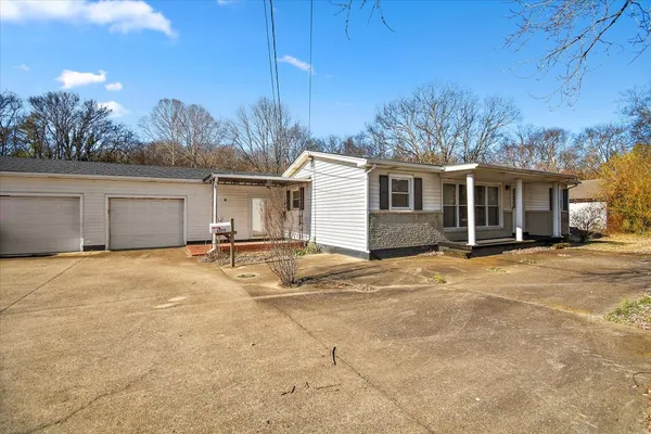 a view of a house with backyard and trees