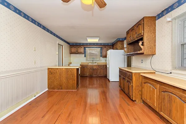 a view of a kitchen with stainless steel appliances granite countertop a stove a sink and a refrigerator