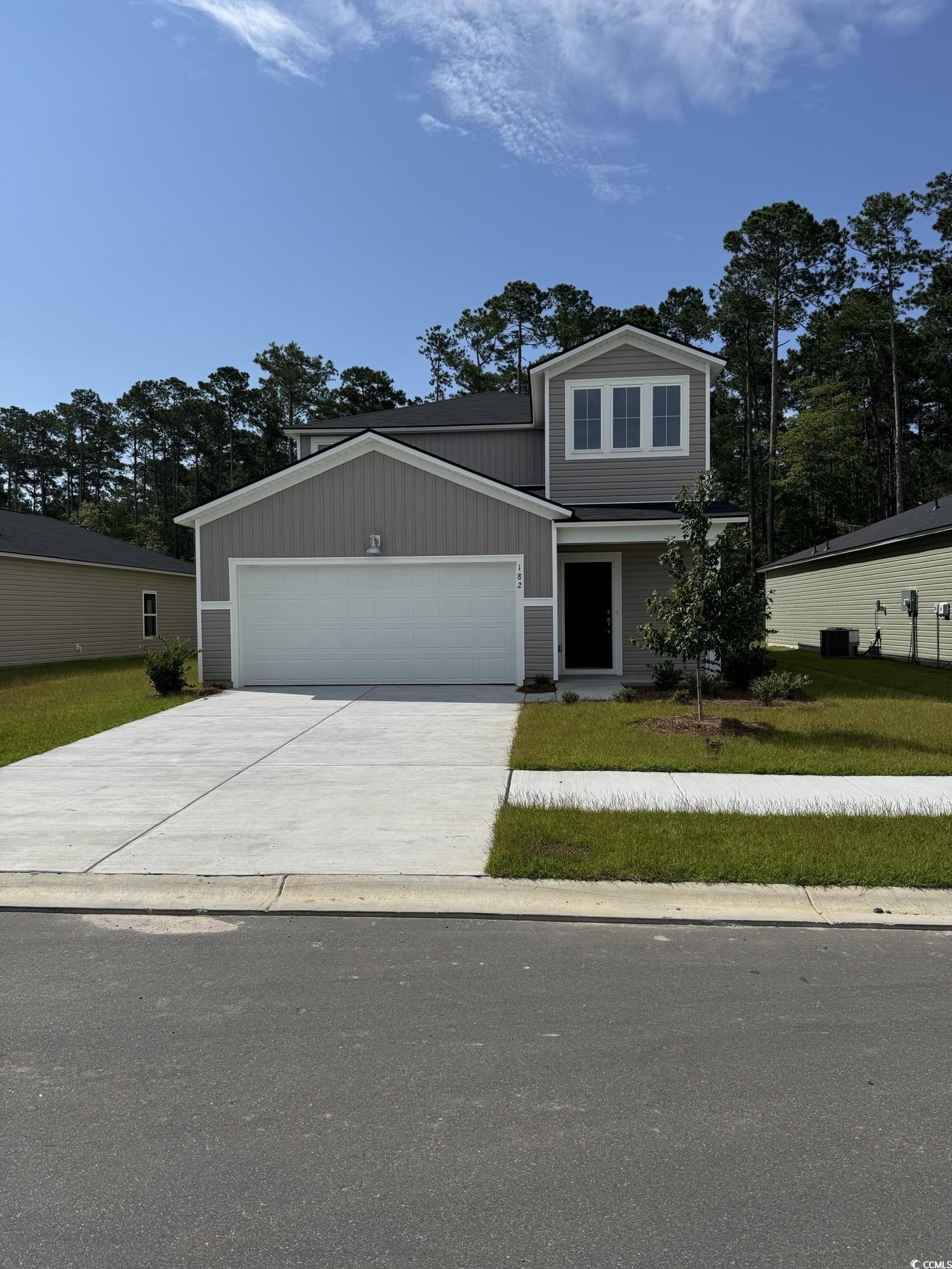Traditional home with a garage, driveway, and a fr