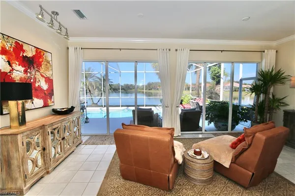 a living room with furniture a flat screen tv and a floor to ceiling window