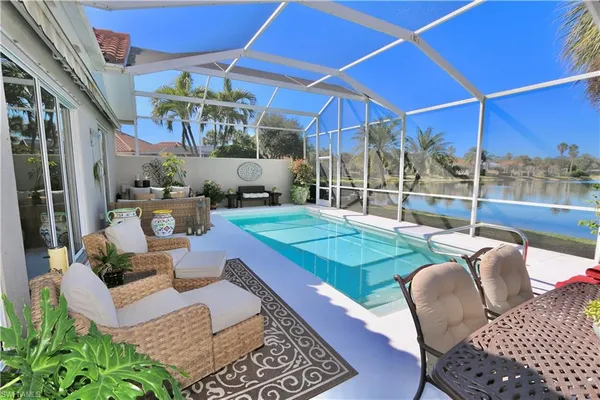 a patio with glass top table and chairs