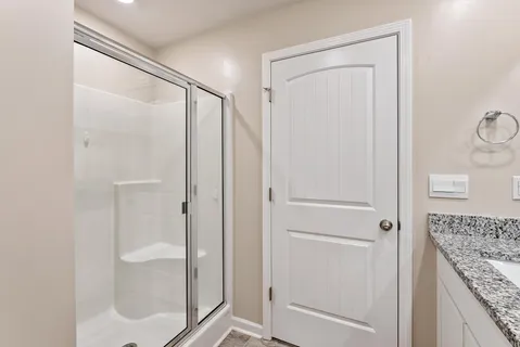 a bathroom with a granite countertop shower and a sink