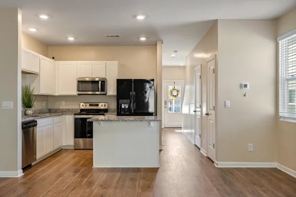 a kitchen with stainless steel appliances a refrigerator a stove top oven a sink and cabinets