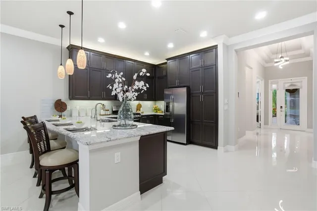 a kitchen with stainless steel appliances kitchen island granite countertop a sink and a refrigerator