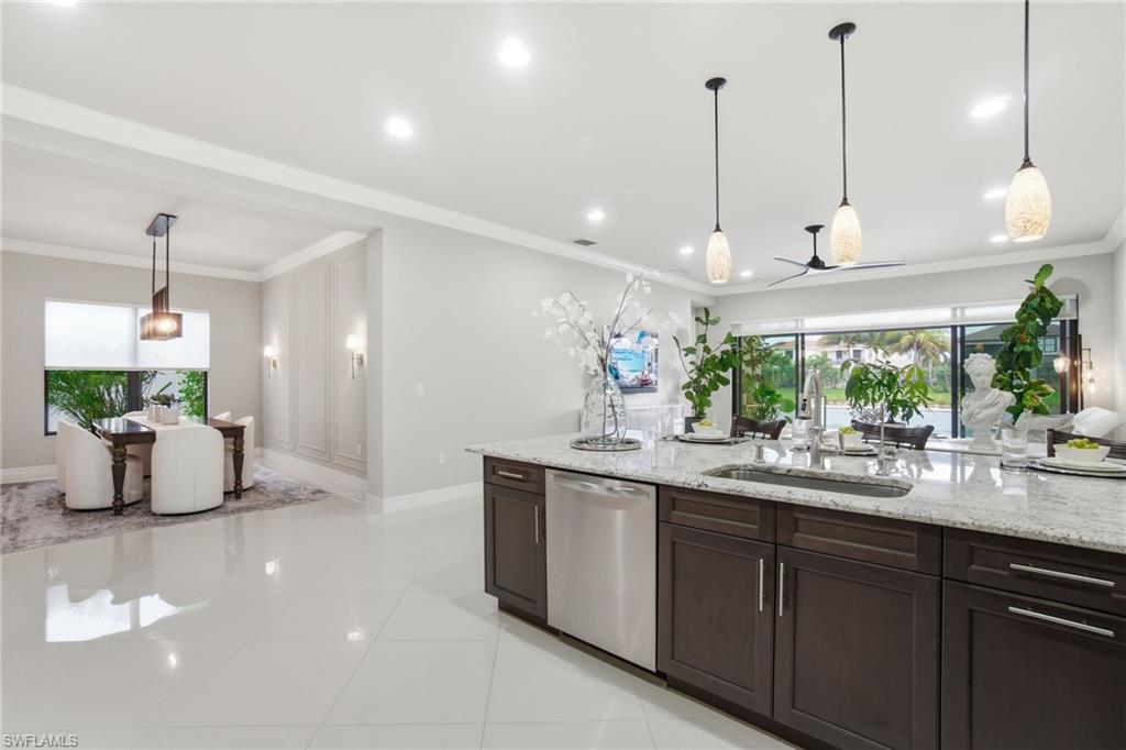 4318 Aurora Street Naples, FL 34119 - Photo 13 of 50 Kitchen featuring decorative light fixtures, dishwasher, light stone counters, dark brown cabinets, and crown molding