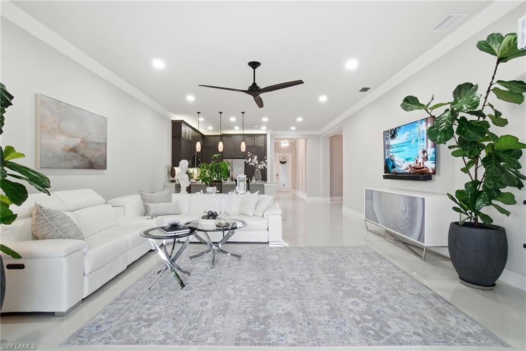 4318 Aurora Street Naples, FL 34119 - Photo 17 of 50 Spacious open-concept living room with crown molding, recessed lighting, and designer finishes.