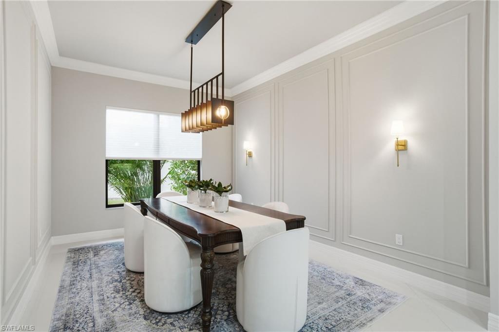 4318 Aurora Street Naples, FL 34119 - Photo 19 of 50 Refined formal dining room highlighted by custom wall paneling, modern lighting, and a serene neutral palette, creating an elegant entertaining space.
