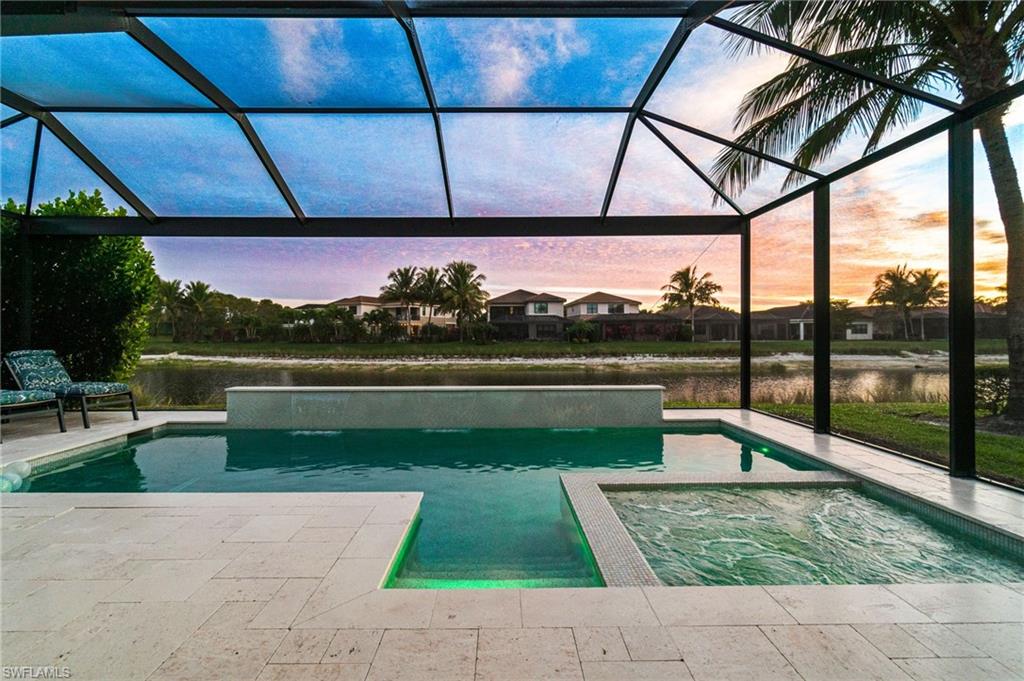 4318 Aurora Street Naples, FL 34119 - Photo 2 of 50 Stunning sunset and lake views from the screened lanai featuring a custom pool and connected spa.