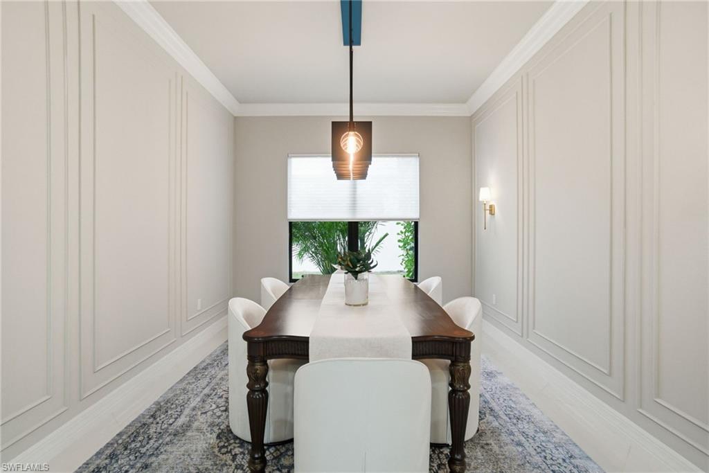 4318 Aurora Street Naples, FL 34119 - Photo 21 of 50 Dining area with crown molding, a decorative wall, and wood finished floors