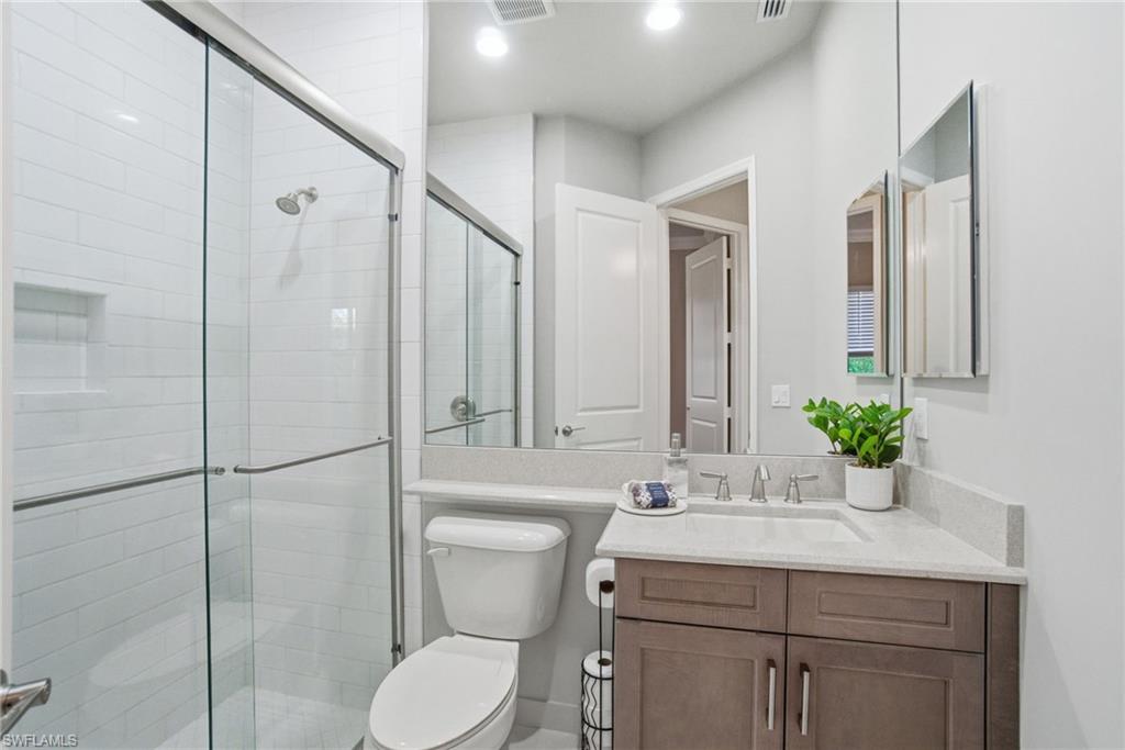 4318 Aurora Street Naples, FL 34119 - Photo 29 of 50 Light and airy full bath with glass-enclosed shower, quartz vanity, and recessed lighting