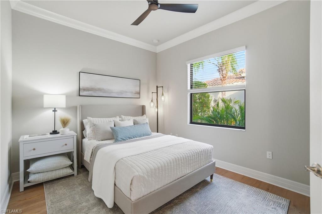 4318 Aurora Street Naples, FL 34119 - Photo 30 of 50 Bright bedroom with crown molding, wood-look floors, and ceiling fan overlooking lush landscaping