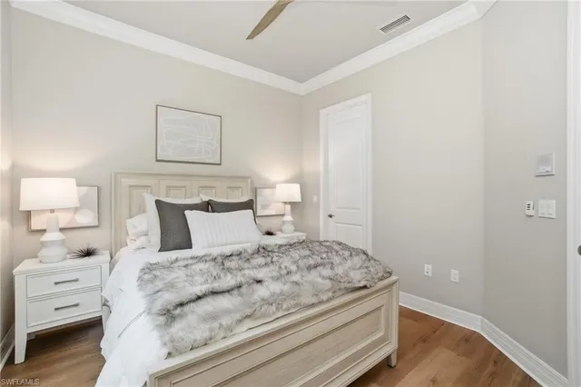 a bedroom with a bed and a lamp on the dresser