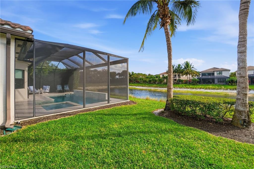 4318 Aurora Street Naples, FL 34119 - Photo 38 of 50 Beautifully landscaped backyard with screened lanai, pool, and water views