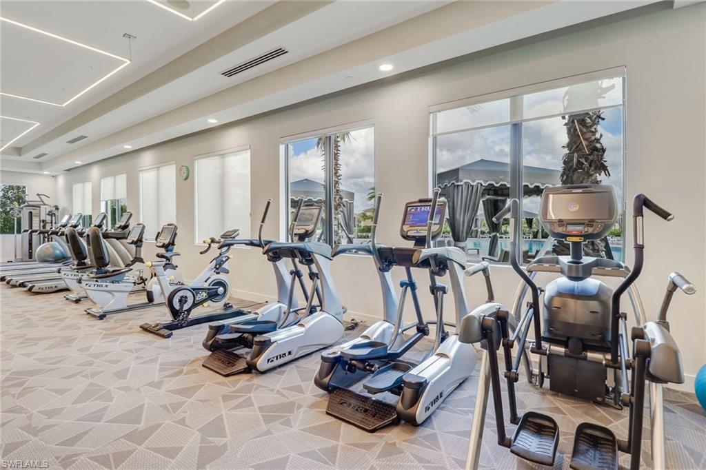 4318 Aurora Street Naples, FL 34119 - Photo 48 of 50 Well-appointed community fitness center with modern cardio equipment, abundant natural light, and recessed lighting.