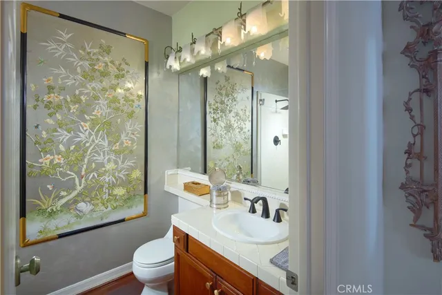 a bathroom with a granite countertop sink toilet a mirror and shower