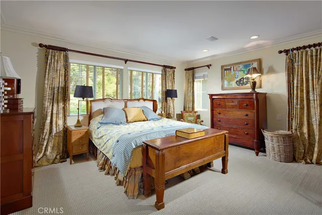 a bed sitting in a spacious bedroom next to a window