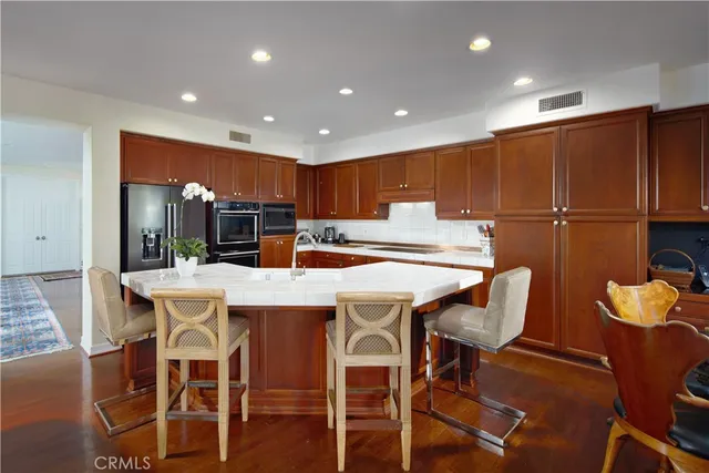 a kitchen with a table chairs refrigerator and cabinets