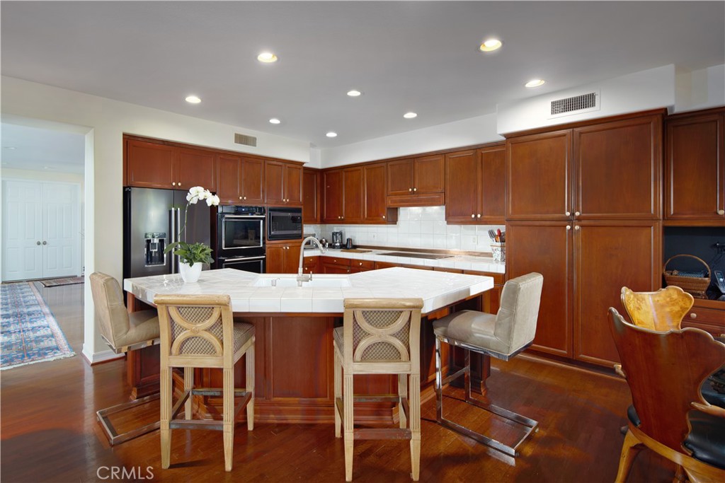 1432 Sea Ridge Drive Newport Beach, CA 92660 - Photo 9 of 25 a kitchen with a table chairs refrigerator and cabinets