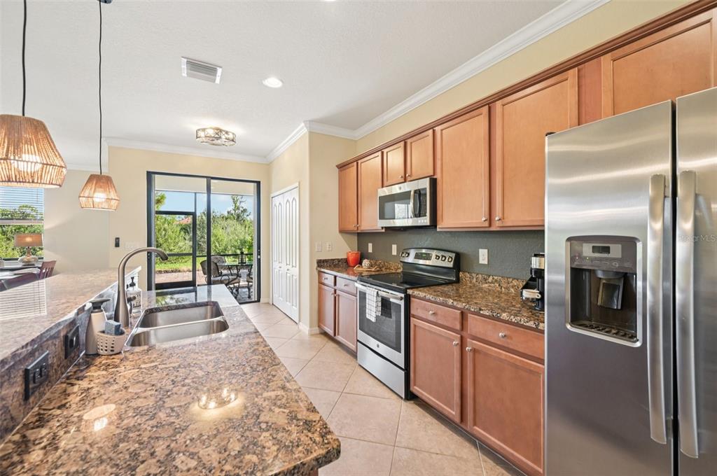 12680 Richezza Drive Venice, FL 34293 - Photo 11 of 57 a large kitchen with stainless steel appliances granite countertop a refrigerator stove top oven and sink