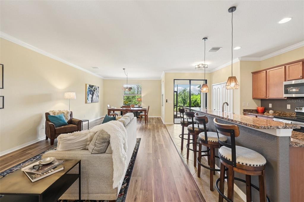 12680 Richezza Drive Venice, FL 34293 - Photo 12 of 57 a view of a dining room and livingroom with furniture wooden floor a rug and a chandelier